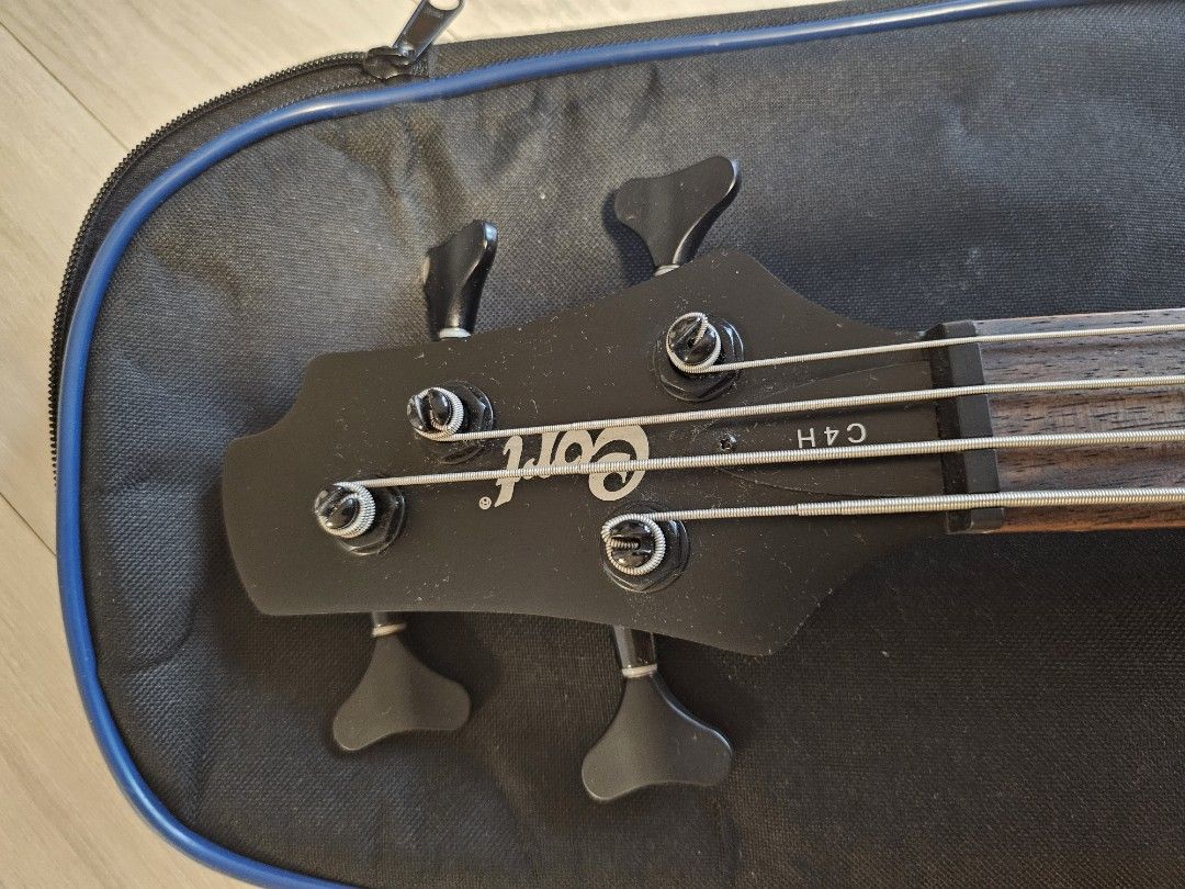 Cort C4H 4-Bass Guitar (Category: Musical Instruments) located in Manila. Submitted by minimalistbyheart (Listing ID 1469960227, Image 3). Description: - Model: Cort C4H Electric Bass Guitar - Finish: Sleek Matte Black - Pickups: Dual Humbucking pickups for a powerful tone - Fretboard: Dark wood - Origin: Made in Indonesia (Serial Number: 100312260) - Inclusions: Padded Cort gig bag, instrument cable, instruction DVD, and warranty card - Conditio