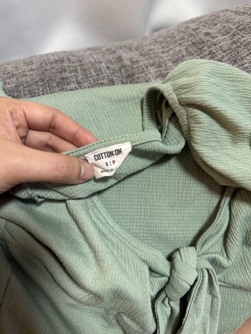 Cotton On Sage Green Tie-Front Crop Top (Category: Sleeveless) located in Calamba. Submitted by cheriiv (Listing ID 1469949837, Image 3). Description: - Brand: Cotton On - Size: Small - Color: Sage Green - Material: Textured waffle-like fabric - Design: Short cap sleeves with slight puff detail, sweetheart neckline, and front tie-knot - Styling: Great to pair with high-waisted jeans or skirts.