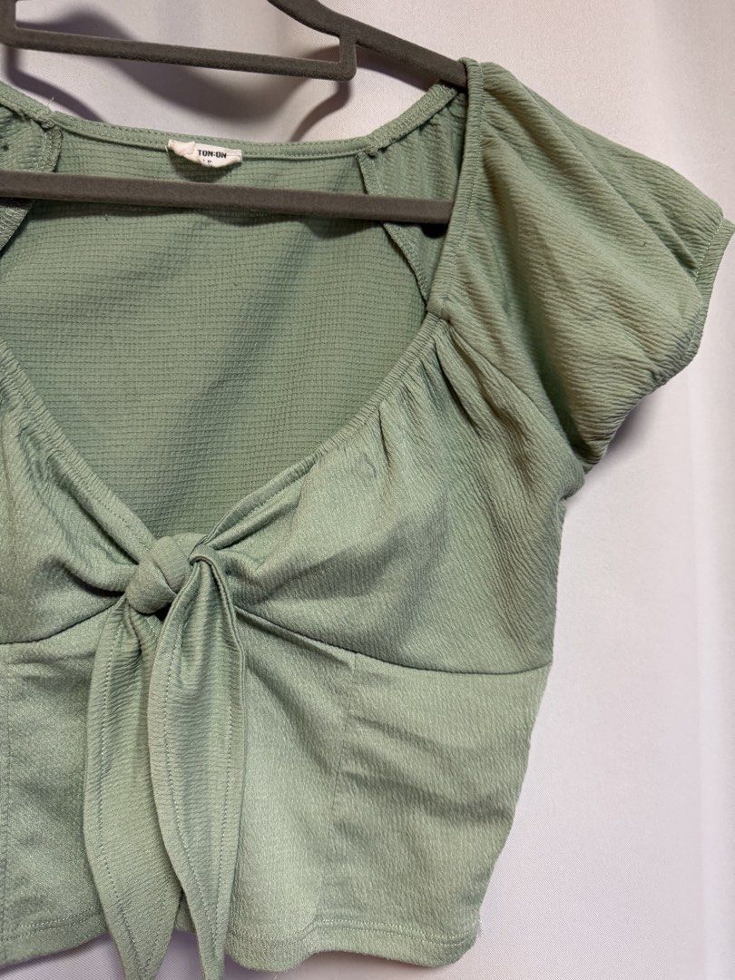 Cotton On Sage Green Tie-Front Crop Top (Category: Sleeveless) located in Calamba. Submitted by cheriiv (Listing ID 1469949837, Image 2). Description: - Brand: Cotton On - Size: Small - Color: Sage Green - Material: Textured waffle-like fabric - Design: Short cap sleeves with slight puff detail, sweetheart neckline, and front tie-knot - Styling: Great to pair with high-waisted jeans or skirts.