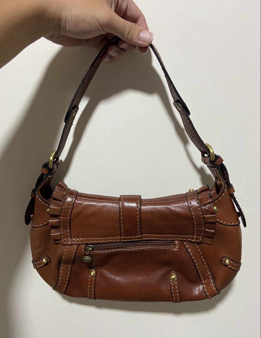 COWA Brown Leather Shoulder Bag with Studs and Ruffles (Category: Shoulder Bags) located in Binan City. Submitted by doze16 (Listing ID 1470036174, Image 2). Description: COWA brown leather shoulder bag. Detailed with brass studs, front strap buckle, and ruffle trim along the flap. Includes a zippered pocket on the back. Adjustable strap with metal hardware. Compact size, great for daily use or going out..