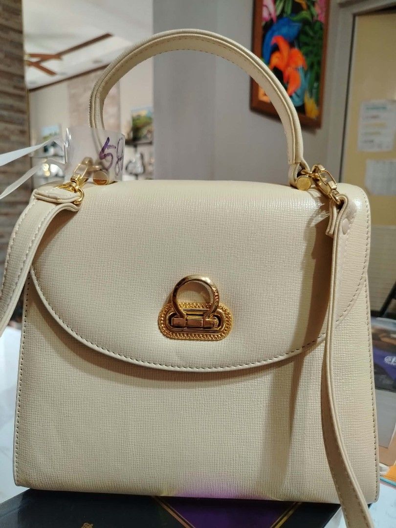 Cream Top Handle Bag With Detachable Strap (Category: Shoulder Bags) located in Paranaque City. Submitted by yensfashionfinds (Listing ID 1469974033, Image 2). Description: - Color: Versatile cream (matches any daily outfit) - Material: Genuine leather with premium gold-tone hardware - Closure: Unique front flap lock closure - Straps: Includes a sturdy top handle and a long, adjustable shoulder strap with buckle detail - Interior: Clean, lined in