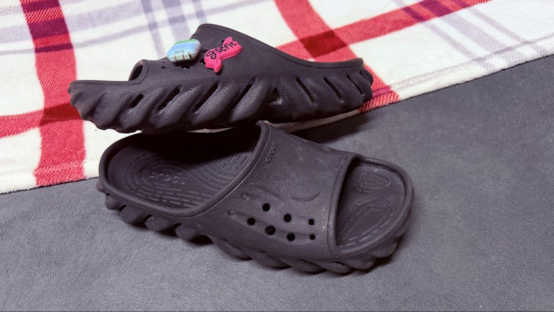 Crocs Echo Slide Black with Jibbitz M5/W7 (Category: Slippers and slides) located in Cavite. Submitted by rhea0218 (Listing ID 1470031341, Image 1). Description: - Item: Black Crocs Echo Slides - Style: Futuristic chunky sculpted sole design - Inclusions: Two Jibbitz charms (small pink text charm and light blue block charm) - Condition: Pre-owned with light wear on tread and footbed, clean overall shape - Type: Slip-on casual footwear.