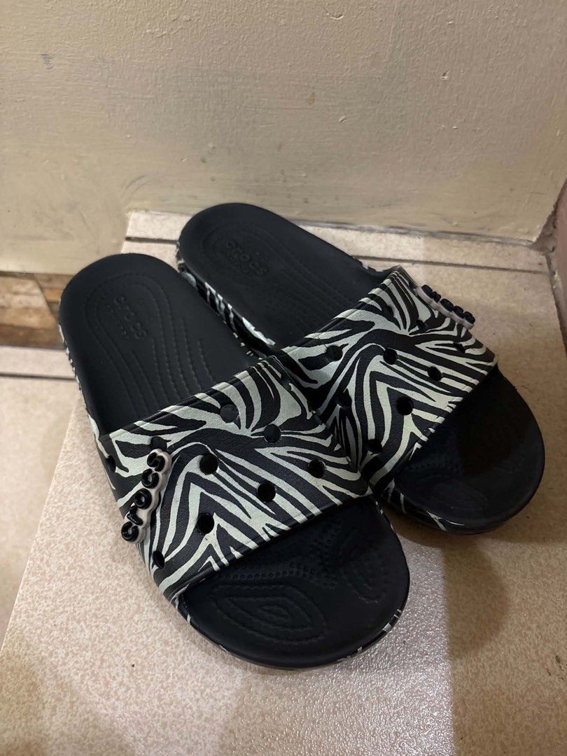 Crocs Zebra Print Slide Sandals Black White (Category: Slippers and slides) located in San Juan City. Submitted by kimtiongson (Listing ID 1469956918, Image 1). Description: - Trendy black and white zebra pattern - Classic slip-on design for easy wear - Textured footbed provides better grip and comfort - Adorned with a small Crocs lettering charm on the strap - Durable black sole with debossed branding - Lightweight, waterproof, and super easy to