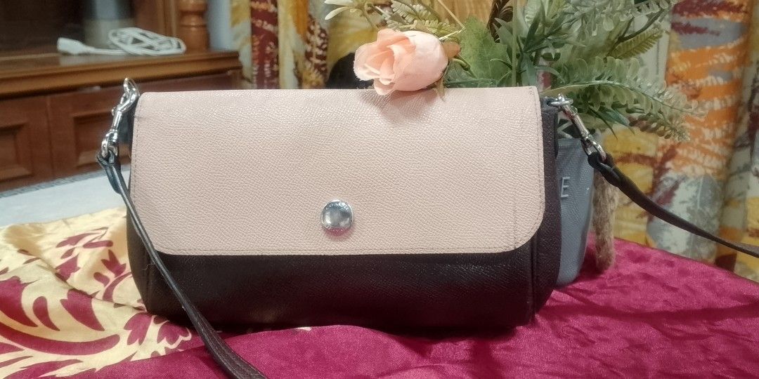 Dark brown textured reversible coach (Category: Shoulder Bags) located in Manila. Submitted by annemil_1984 (Listing ID 1469828309, Image 1). Description: - Color/Material: Dark brown textured leather - Closure: Flap top with silver-tone snap button - Hardware: Silver-tone clips and accents - Design: Structured sides with clean stitching - Versatility: Includes a removable strap for multiple styling options - Capacity: Compact size, ideal for dai