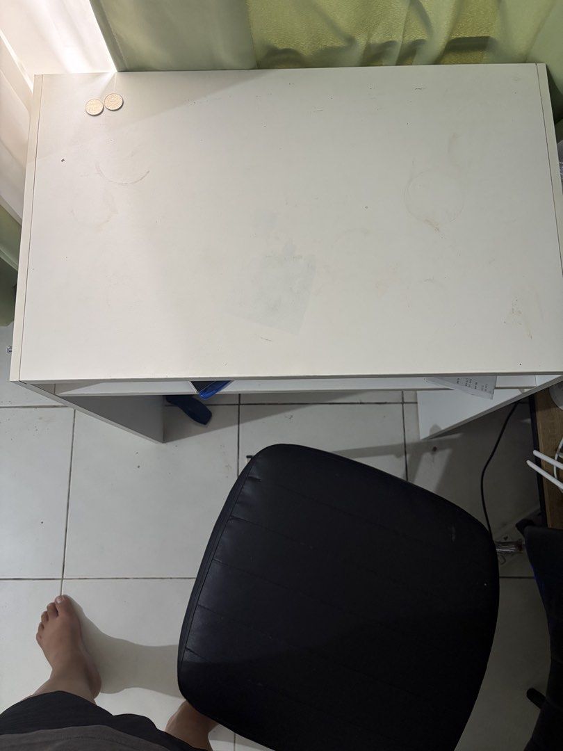 Decluttering: IKEA Study Table (IKEA TORALD DESK) (Category: Tables & Sets) located in Manila. Submitted by herreramar34596 (Listing ID 1470006323, Image 2). Description: - Color & Material: Sturdy white wooden construction - Design: Compact size with straight legs and an open middle shelf for papers and small items - Condition: Minor wear and marks on the surface from regular use; visible screw heads on the side panel Dimensions: 65 x 40 cm (25 