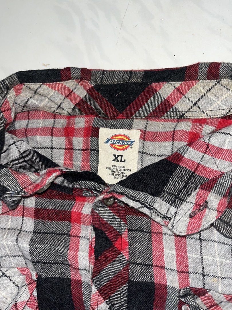 Dickies Red Black Plaid Flannel Shirt (Category: Tshirts & Polo Shirts ) located in Nabua. Submitted by lastthrift2.0 (Listing ID 1469989286, Image 2). Description: Excellent condition - Style: Classic red, black, and white plaid flannel shirt - Size: XL - Material: 100% soft cotton - Features: Dual chest pockets with button closures, button-up front, and button cuffs - Condition: Great for layering in cooler weather.