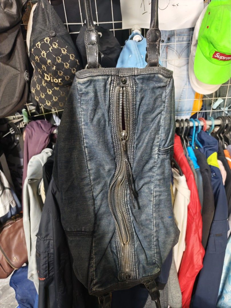 Diesel Denim Shoulder Bag Handbag (Category: Shoulder Bags) located in Isulan. Submitted by jaysthrift (Listing ID 1470027424, Image 3). Description: - Authentic vintage Diesel denim shoulder bag - Blue washed denim exterior with black leather handles and trim - Front zipper pocket featuring Diesel branded hardware - Eye-catching bright pink inner lining with an extra denim slip pocket - Original Diesel paper tag still attached - Utilitarian Y2K 