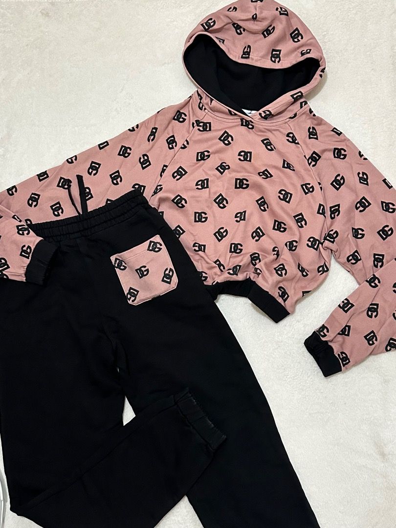 Dolce & Gabbana Pink Black Monogram Tracksuit Set (Category: Luxury Apparel) located in Adams. Submitted by ni-collection26 (Listing ID 1470028408, Image 1). Description: - Brand: Dolce & Gabbana - Set includes: Pink monogram pullover hoodie & matching black joggers - Hoodie details: Black contrasting hood interior and cuffs - Jogger details: Elastic drawstring waistband, cuffed ankles, and single pink monogram back pocket - Material: Ultra-soft 