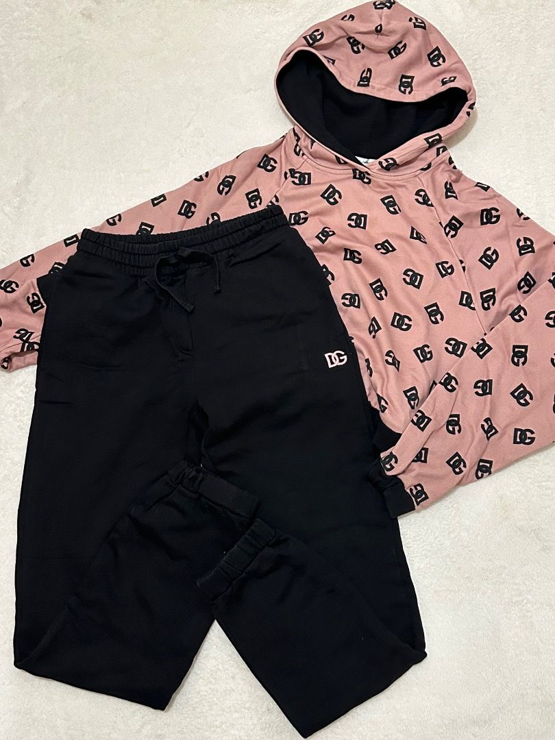 Dolce & Gabbana Pink Black Monogram Tracksuit Set (Category: Luxury Apparel) located in Adams. Submitted by ni-collection26 (Listing ID 1470028408, Image 3). Description: - Brand: Dolce & Gabbana - Set includes: Pink monogram pullover hoodie & matching black joggers - Hoodie details: Black contrasting hood interior and cuffs - Jogger details: Elastic drawstring waistband, cuffed ankles, and single pink monogram back pocket - Material: Ultra-soft 