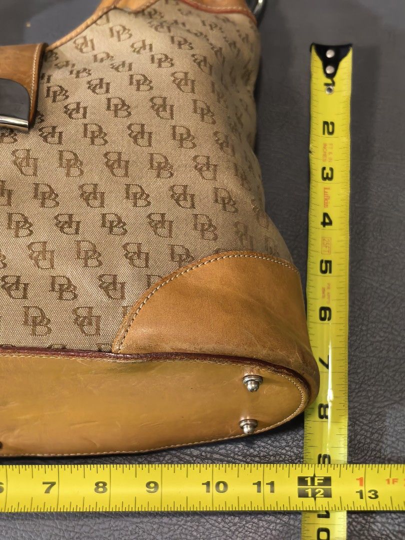 Dooney & Bourke Monogram Canvas Shoulder Bag (Category: Luxury Bags & Wallets) located in Cagayan de Oro. Submitted by pootx (Listing ID 1470091542, Image 2). Description: -please check the last photo sa issue - Authentic Dooney & Bourke shoulder bag - Khaki monogram canvas with durable tan leather trim and base - Secure front strap with classic turn-lock closure - Shiny silver-tone hardware and protective metal feet - Spacious interior lined wit