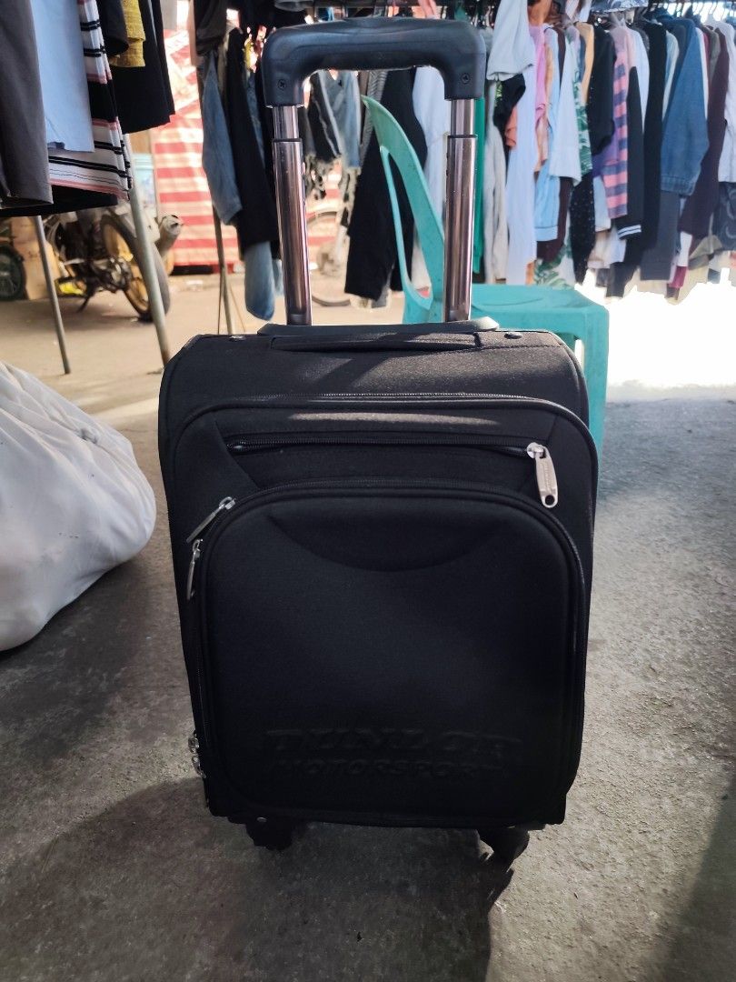 Dunlop Motorsport Black Rolling Suitcase (Category: Luggage) located in Bulacan. Submitted by gelvy1316 (Listing ID 1469947585, Image 2). Description: - Brand: Dunlop Motorsport - Color: Classic black - Ideal for: Short trips and weekend getaways - Mobility: Retractable handle and smooth-rolling wheels - Exterior: Convenient front zipped pocket for quick-access items - Interior: Clean grey branded lining with cross packing straps - Organization: 