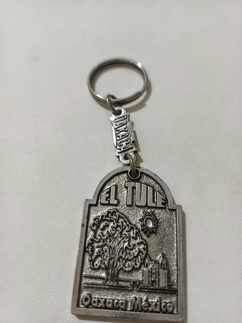 El Tule Tree Oaxaca Mexico Souvenir Keychain (Category: Vintage Collectibles) located in Abucay. Submitted by thrifty.picked (Listing ID 1470105948, Image 1). Description: - Authentic souvenir keychain from Oaxaca, Mexico - Heavy silver-tone plaque charm featuring the famous El Tule tree and a church - Detailed relief design with engraved 'EL TULE' and 'Oaxaca Mexico' text - Sturdy split ring attached via an 'OAXACA'-stamped link - Solid, high-qu