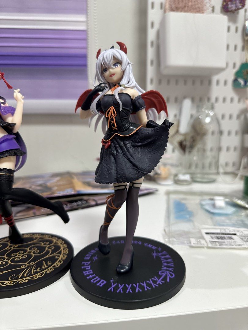 Elaina figure wandering witch (Category: Figurines & Statues) located in Manila. Submitted by silentfire.54ea36 (Listing ID 1470117010, Image 1). Description: - Character: Albedo (Devil Outfit version) from Overlord - Features: White hair, black dress with orange lacing, tiny red horns, and small red wings - Base: Round black base with purple lettering - Condition: Displayed only, adult-owned, smoke-free environment - Perfect for Overlord and ani