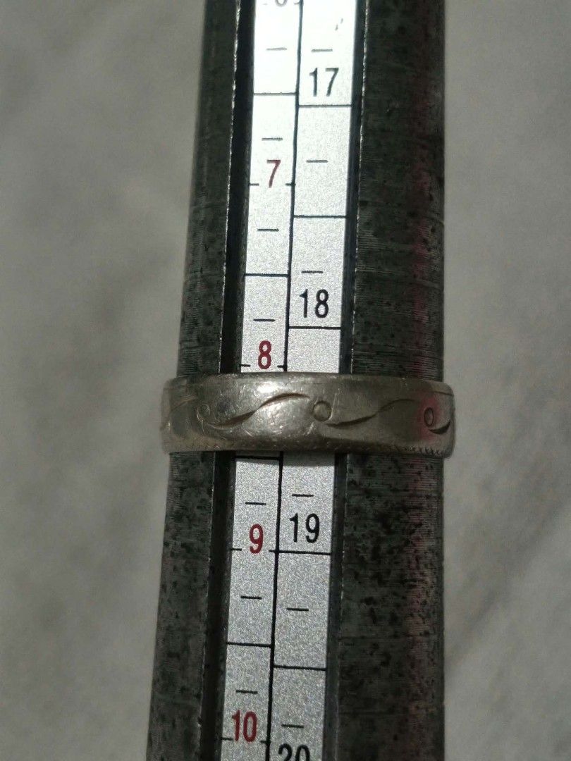 Engraved metal band ring size 18 (Category: Rings) located in Abucay. Submitted by thrifty.picked (Listing ID 1470121329, Image 1). Description: - Material: Silver 925 metal with solid construction and a flat profile - Design: Engraved wave and dot pattern around the band - Size: Approximately 18mm inner diameter - Condition: Shows surface wear and minor tarnishing from regular use.