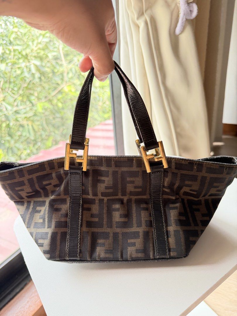 Fendi Mini Triangle Tote Bag (With Entrupy COA) (Category: Tote Bags) located in Marikina City. Submitted by reloved8 (Listing ID 1469738000, Image 3). Description: ✨ VINTAGE FENDI MINI TRIANGLE TOTE BAG IN TOBACCO ZUCCA CANVAS ✨ Selling my authentic, highly collectible vintage Fendi Mini Triangle Boat Tote Bag. This features the iconic interlocking FF monogram jacquard canvas with dark brown genuine leather handles and trim. Unlike the common fl