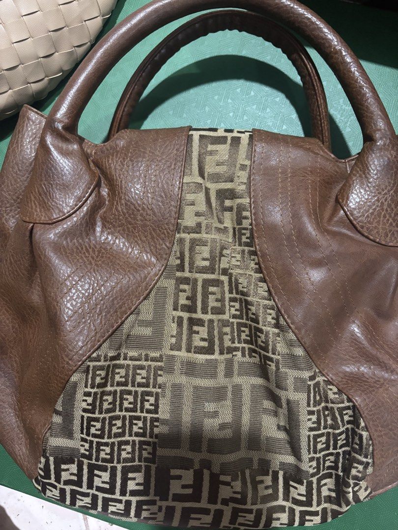 Fendi Zucca Print Brown Leather Handbag (Category: Luxury Bags & Wallets) located in Rizal. Submitted by riri.rarapreloved (Listing ID 1469983462, Image 2). Description: - Brand: Fendi - Material: Brown leather and Zucca monogram fabric - Design: Structured everyday bag with double top handles and flap closure with metallic buckle hardware - Interior: Gold-tone lining with a secure zipper pocket and metal Fendi logo plaque - Condition: Excellent,