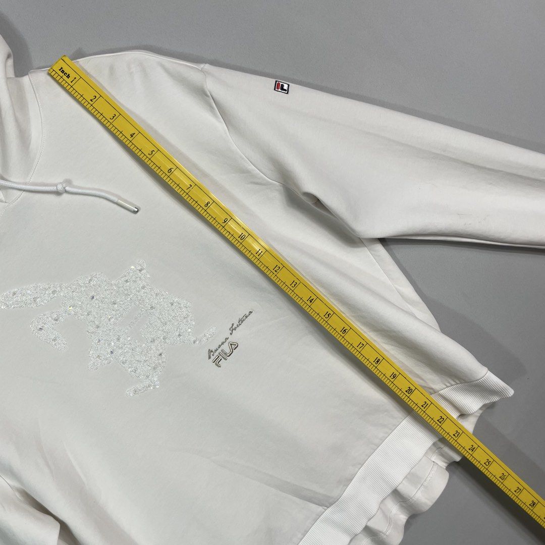 FILA | White Graphic Hoodie (Category: Hoodies) located in Manila. Submitted by sevenjscloset (Listing ID 1470005010, Image 2). Description: - Brand: FILA - Color: White with sparkly chest graphic - Size: Medium (Length: 23.5", Width: 20") - Model reference: 5'2", 50kg - Condition: Excellent, no issues, worn a few times and kept clean.