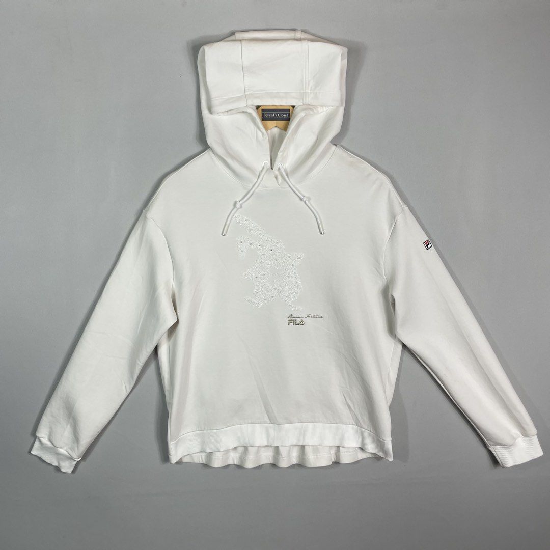 FILA | White Graphic Hoodie (Category: Hoodies) located in Manila. Submitted by sevenjscloset (Listing ID 1470005010, Image 1). Description: - Brand: FILA - Color: White with sparkly chest graphic - Size: Medium (Length: 23.5", Width: 20") - Model reference: 5'2", 50kg - Condition: Excellent, no issues, worn a few times and kept clean.