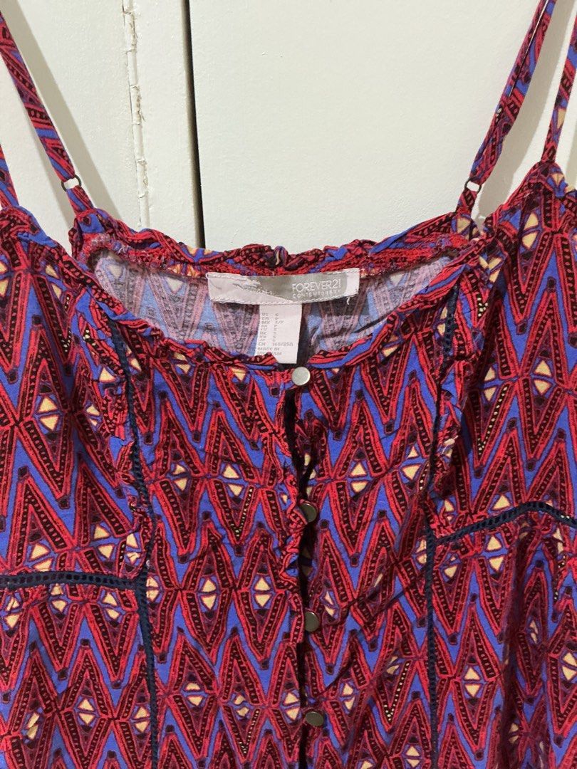 Forever 21 Aztec Print Button Front Camisole Dress (Category: Dresses) located in Rizal. Submitted by kyliemaine (Listing ID 1470032397, Image 2). Description: - Brand: Forever 21 - Size: S - Design: Vibrant red and blue Aztec pattern with lace-trim paneling - Features: Adjustable spaghetti straps, button-down front with metal buttons, and gathered neckline - Material: Lightweight fabric - Style: Casual summer piece, easy to pair with sandals or 