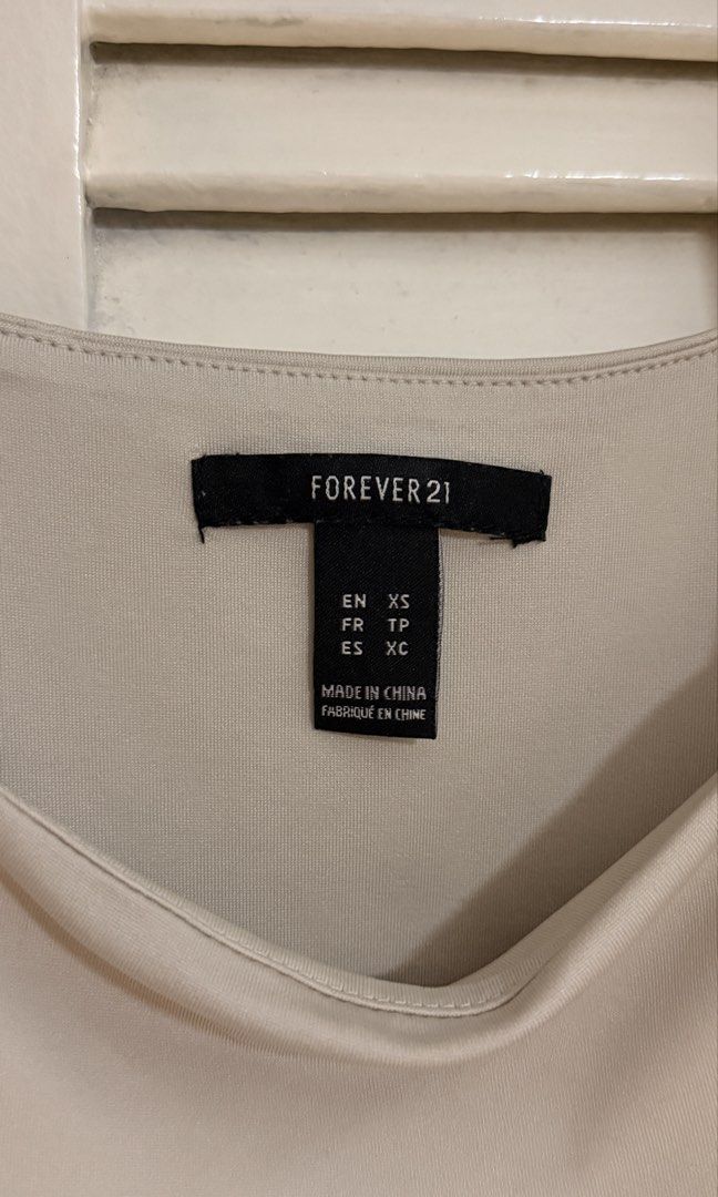 Forever 21 Beige Square Neck Bodysuit (Category: Sleeveless) located in Quezon City. Submitted by oliviablanche (Listing ID 1470085540, Image 2). Description: - Brand: Forever 21 - Size: XS - Color: Light Beige / Nude - Neckline: Square neckline with wide tank straps and square back cut - Details: Smooth, stretch fabric with a fitted silhouette and snap-button closure at the bottom - Styling: Minimalist wardrobe staple, perfect for pairing with h