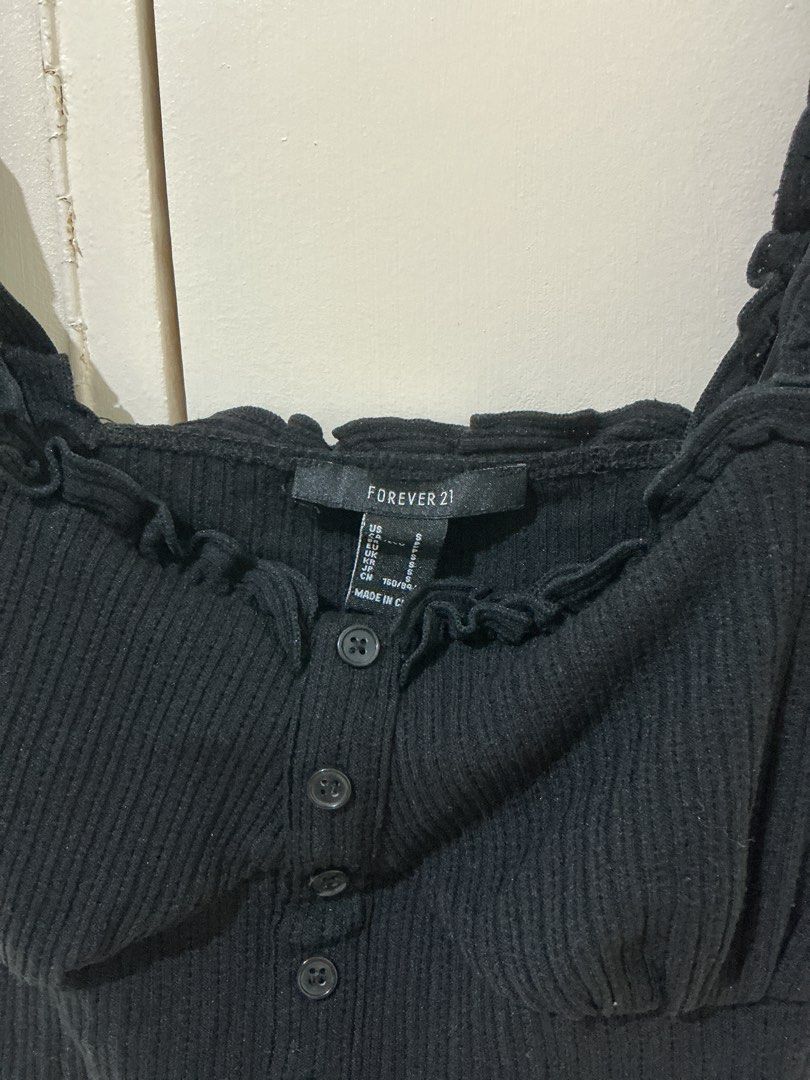 Forever 21 Black Ribbed Ruffle Crop Top (Category: Sleeveless) located in Rizal. Submitted by kyliemaine (Listing ID 1470034684, Image 2). Description: - Brand: Forever 21 - Size: Small - Color: Black - Style: Cropped, fitted ribbed top - Details: Square neckline, ruffled straps, and center front button closure - Perfect for pairing with high-waisted jeans, shorts, or skirts.