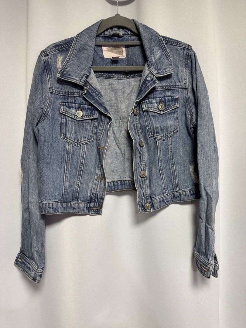 Forever 21 Cropped Denim Jacket (Category: Coats, Jackets and Outerwear) located in Calamba. Submitted by cheriiv (Listing ID 1469951111, Image 1). Description: - Brand: Forever 21 Contemporary - Size: Small - Wash: Medium wash denim - Fit: Cropped cut with classic collar and button cuffs - Details: Button-front closure, two chest pockets, and stylish distressing near the hem and shoulders.