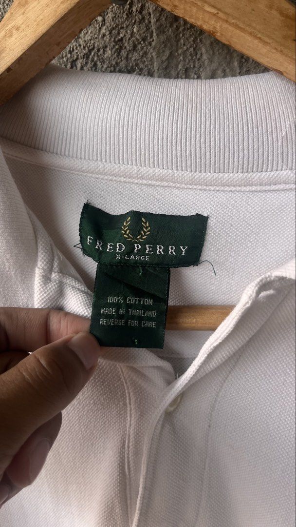 Fred Perry White Polo Shirt X-Large (Category: Tshirts & Polo Shirts ) located in Cabuyao City. Submitted by bulandos (Listing ID 1470033605, Image 2). Description: - Brand: Fred Perry - Color: White with red and blue tipping stripes - Size: X-Large (Classic Fit) - Material: 100% Cotton, Made in Thailand - Details: Ribbed collar, button placket, and embroidered laurel wreath logo on chest - Care: Machine wash cold - Shipping: Fast shipping via J&