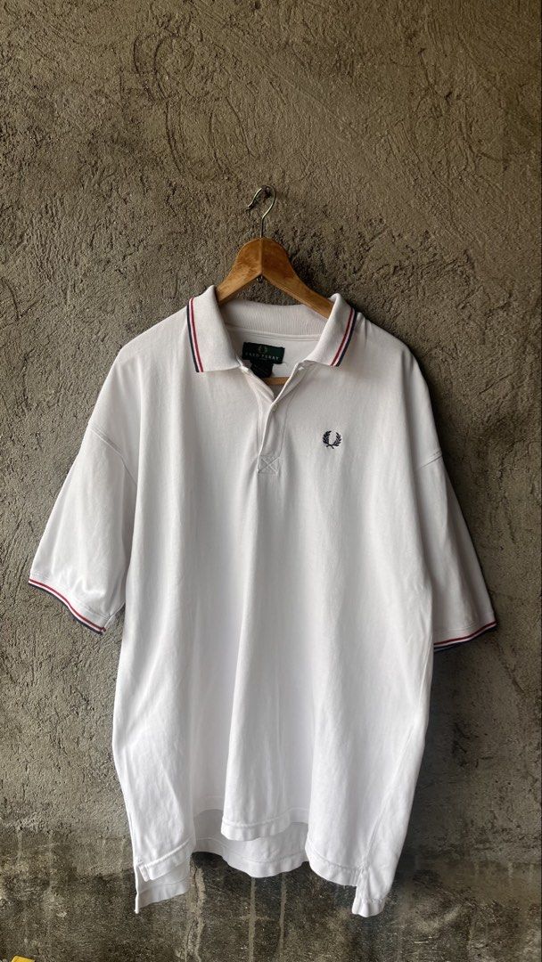 Fred Perry White Polo Shirt X-Large (Category: Tshirts & Polo Shirts ) located in Cabuyao City. Submitted by bulandos (Listing ID 1470033605, Image 1). Description: - Brand: Fred Perry - Color: White with red and blue tipping stripes - Size: X-Large (Classic Fit) - Material: 100% Cotton, Made in Thailand - Details: Ribbed collar, button placket, and embroidered laurel wreath logo on chest - Care: Machine wash cold - Shipping: Fast shipping via J&