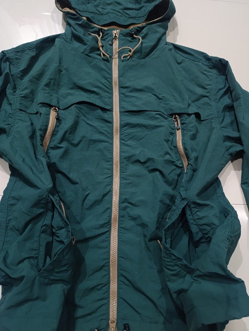 Frizmworks Mountain Wind Parka Dark Green Medium (Category: Coats, Jackets and Outerwear) located in Davao. Submitted by idioticthrifter (Listing ID 1470119917, Image 3). Description: - Brand: Frizmworks - Style: Mountain Wind Parka - Color: Dark Green with contrast tan zippers - Size: Medium - Material: 100% Nylon (Made in Vietnam) - Features: Full zip closure, adjustable hood drawstrings, angled chest zip pockets, and lower hand pockets - Produ