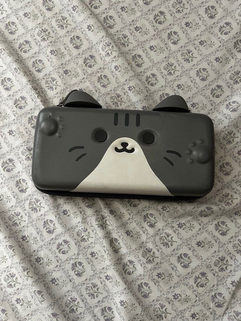 Geekshare Cat eared themed Portable carrying case for Nintendo Switch 2 & OLED (Category: Cases & Covers) located in Quezon City. Submitted by chibicore (Listing ID 1470029150, Image 3). Description: Bought for 1.5k₱ from Orange app *Anti-drop case *Gray tabby color *extra pockets for cartridges & joycons (Minor signs of use pls manage ur expectations ‼️) Loc: Eastwood City, Quezon City.