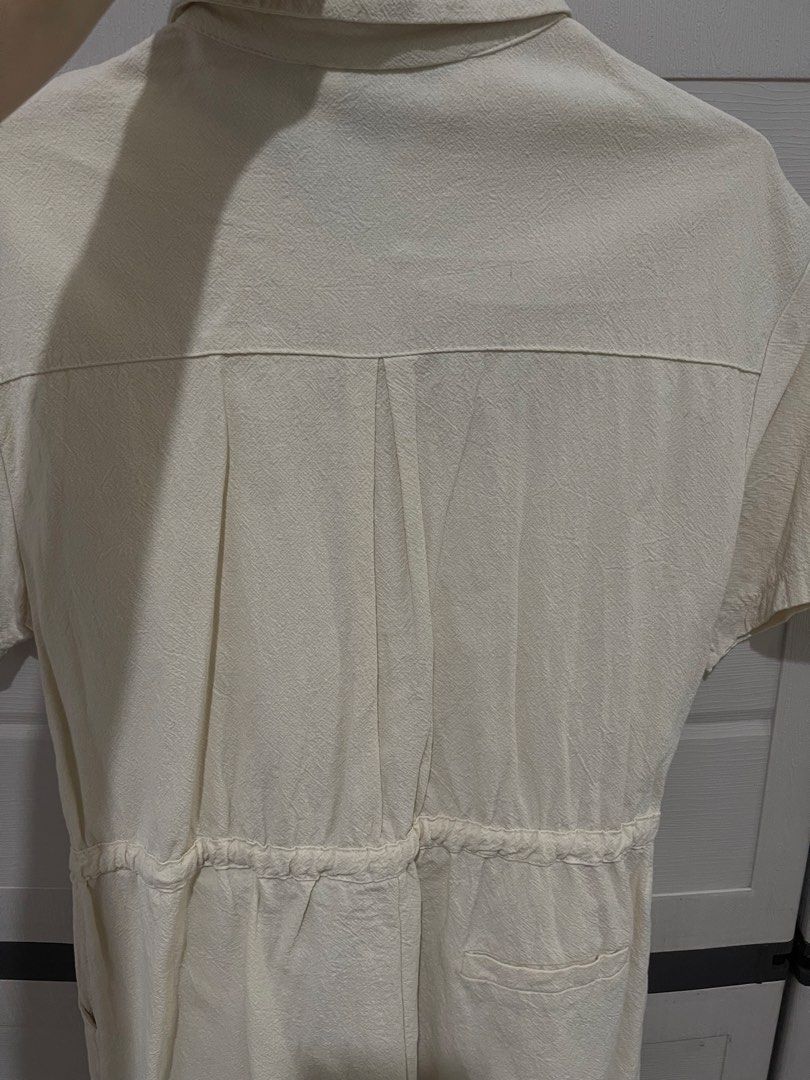 G&G Cream Short Sleeve Button-Up Romper (Category: Rompers) located in Quezon City. Submitted by zntinycloset (Listing ID 1469974160, Image 3). Description: - Brand: G&G - Color: Cream - Style: Short sleeve romper / one-piece - Details: Collared neckline, button-front closure, single chest pocket, and back yoke with pleat detailing - Waist: Elastic waistband with an adjustable drawstring tie - Condition: Clean fabric texture throughout - Perfect 