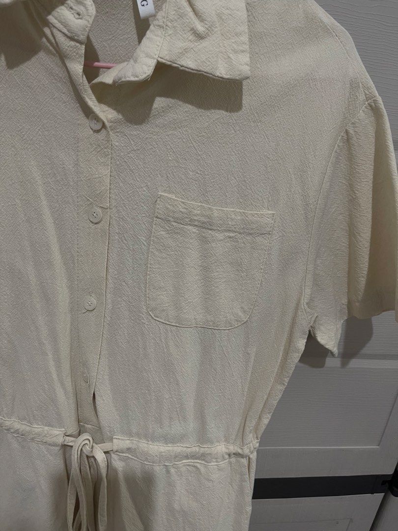 G&G Cream Short Sleeve Button-Up Romper (Category: Rompers) located in Quezon City. Submitted by zntinycloset (Listing ID 1469974160, Image 2). Description: - Brand: G&G - Color: Cream - Style: Short sleeve romper / one-piece - Details: Collared neckline, button-front closure, single chest pocket, and back yoke with pleat detailing - Waist: Elastic waistband with an adjustable drawstring tie - Condition: Clean fabric texture throughout - Perfect 