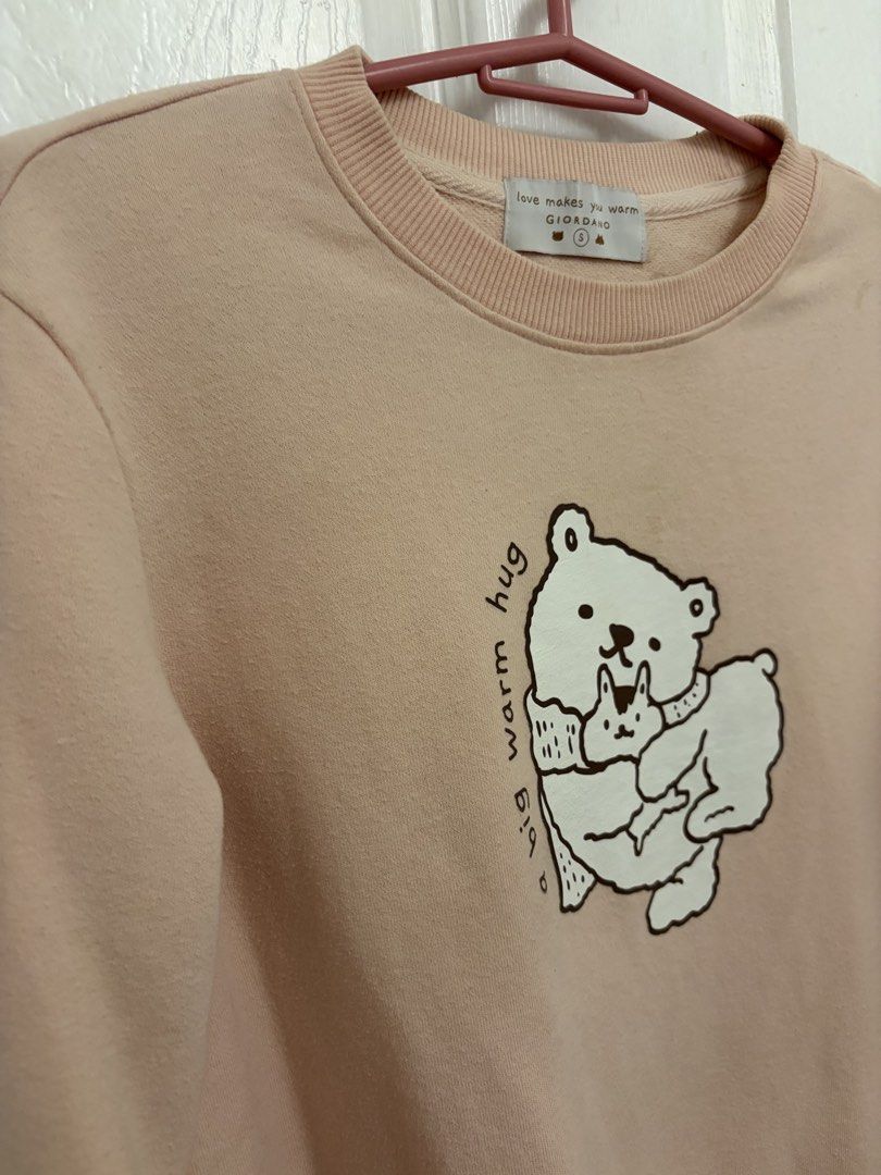Giordano Pink Bear Print Sweatshirt Size S (Category: Coats, Jackets and Outerwear) located in Cabuyao City. Submitted by _camilleeee_ (Listing ID 1470052386, Image 3). Description: - Brand: Giordano - Color: Pastel pink - Size: Small (S) - Design: Cute bear graphic with 'a big warm hug' text and 'love makes you warm' branding - Details: Ribbed collar, cuffs, and hem - Material: Soft cotton blend - Condition: Excellent / Comfortable fit for casua