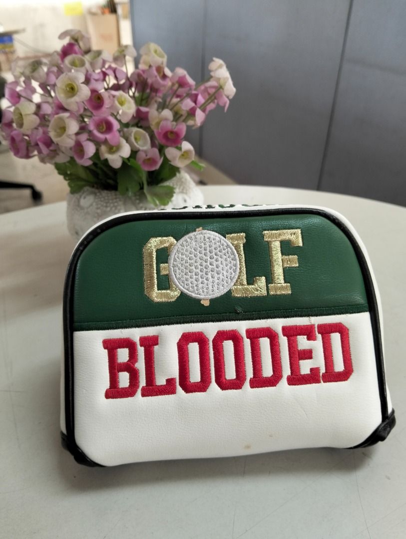 Golf Blooded Putter Head Cover White Green (Category: Golf) located in Binan City. Submitted by croti_by_juliechi (Listing ID 1470138538, Image 1). Description: - Type: Standard mallet style golf putter head cover - Design: White and green faux leather with black piping - Details: Golf ball graphic with gold embroidered 'GOLF' text - Accent: Large, bold red 'BLOODED' embroidery on the bottom section - Condition: Brand new, great for upgrading you