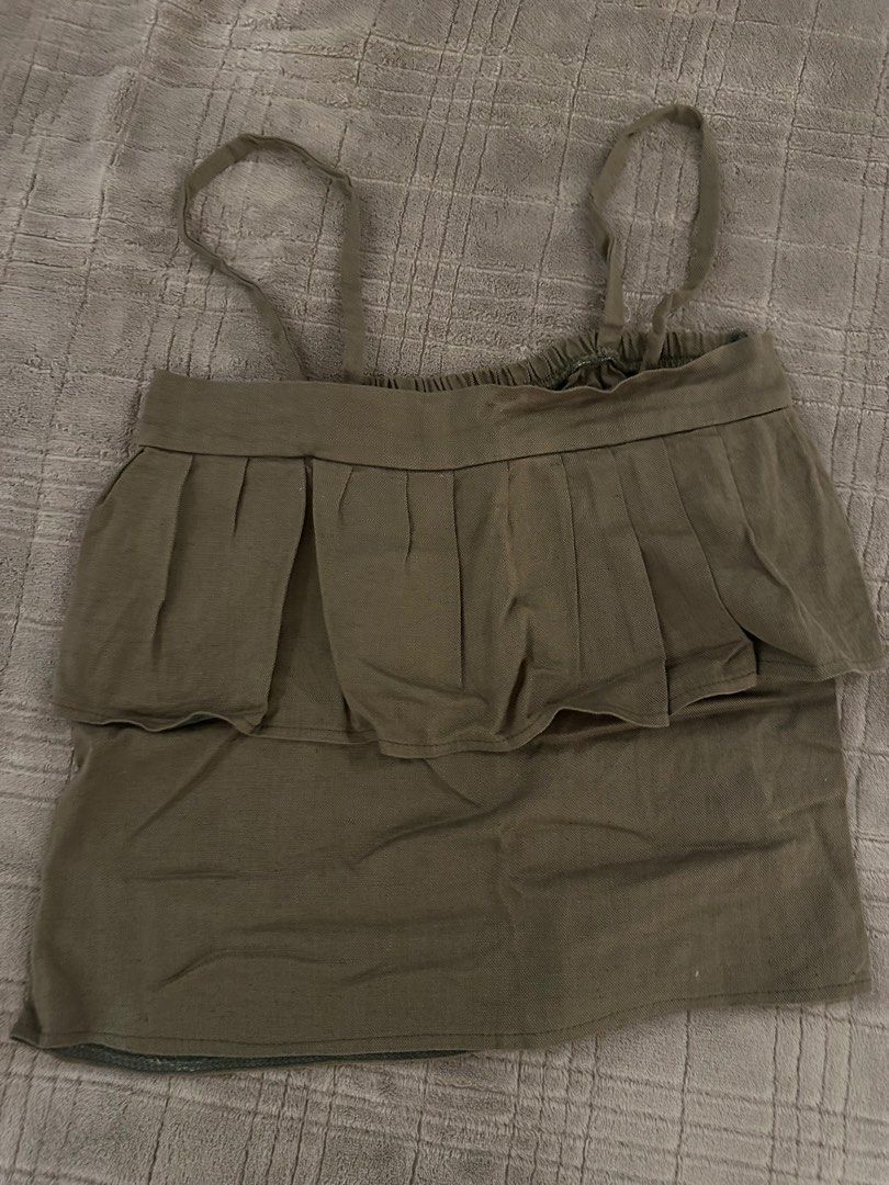 Green Cami Top Ruffle Layer Tank (Category: Sleeveless) located in Manila. Submitted by cabuniagpr58494 (Listing ID 1470077031, Image 1). Description: - Color: Neutral olive green - Design: Gathered elastic neckline with a pleated front ruffle layer - Fit: Relaxed boxy fit - Straps: Thin, adjustable straps with pull-on style - Style: Casual everyday wear, easy to match with denim shorts or skirts.