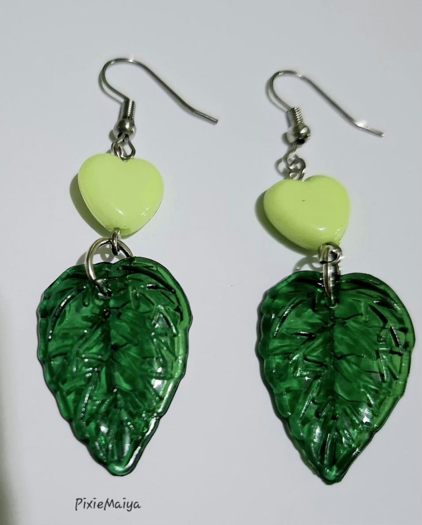 Green leaf heart dangling hook earrings and beaded necklace (Category: Earrings) located in Valenzuela. Submitted by pixieworks64309 (Listing ID 1469949833, Image 2). Description: - Handmade jewelry set including dangling hook earrings and a matching beaded necklace - Features green translucent leaf charms and bright lime green heart beads - Chain designed with alternating bugle and seed beads in various shades of green - Equipped with secure hoo