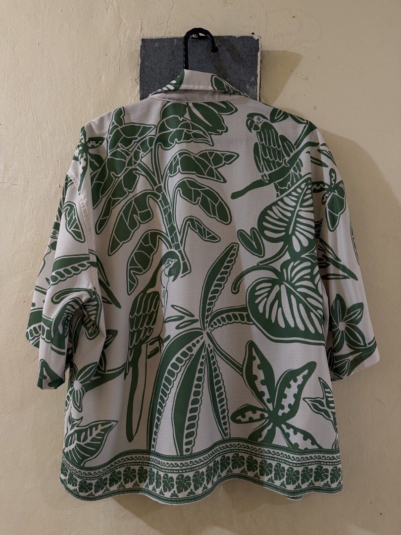 Tropical Cropped Polo (Category: Tshirts & Polo Shirts ) located in Las Pinas. Submitted by rareriroruru (Listing ID 1470052049, Image 2). Description: - Style: Relaxed resort-style short sleeve button-up - Print: Tropical parrot and jungle leaf all-over print with a patterned hem border - Color: Green and off-white - Size: Small - Length: 23.5 in - Width: 24 in - Material: Lightweight and breathable fabric - Ideal for: Summer, beach trips, and c