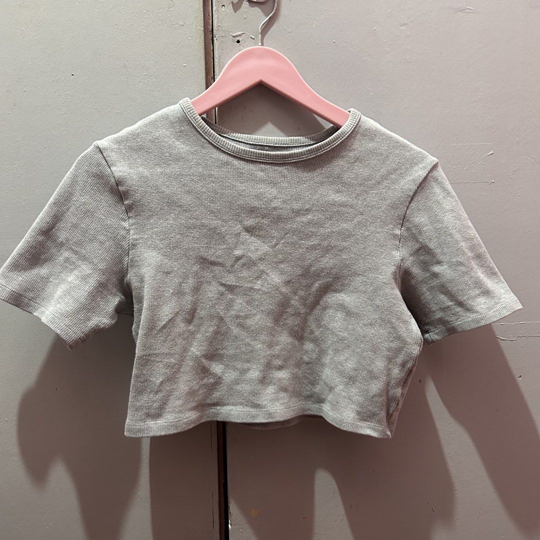 Grey Ribbed Crop Top Short Sleeve Top (Category: Shirts) located in Mandaluyong City. Submitted by strawbyeries (Listing ID 1470086776, Image 1). Description: - Color: Grey - Style: Ribbed crop top with short sleeves and round neckline - Material: Stretchy and super comfortable fabric - Versatility: Easy to pair with high-waisted jeans or skirts - Condition: Worn a few times, no stains or damage.