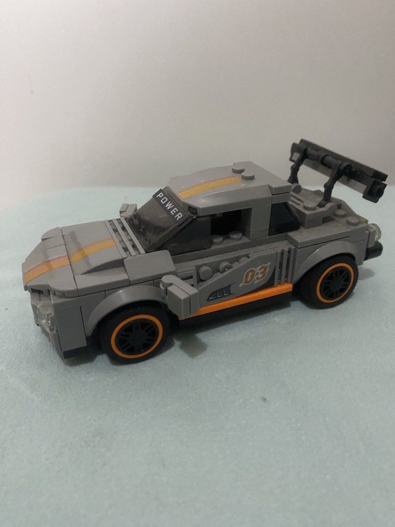 Grey Toy Racing Car Block Build (Category: Lego & Building Sets) located in Quezon City. Submitted by mg163 (Listing ID 1470041086, Image 2). Description: Grey Toy Racing Car Block Build For sale Collectible Already made, no box. As is - Pre love item - Grey building block toy race car with orange and yellow center racing stripes - Features printed number '03' and orange trim on the side doors - Equipped with a large black rear spoiler and 'POWER