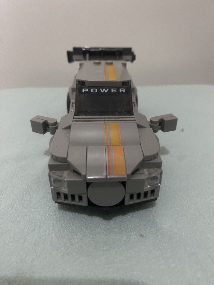 Grey Toy Racing Car Block Build (Category: Lego & Building Sets) located in Quezon City. Submitted by mg163 (Listing ID 1470041086, Image 3). Description: Grey Toy Racing Car Block Build For sale Collectible Already made, no box. As is - Pre love item - Grey building block toy race car with orange and yellow center racing stripes - Features printed number '03' and orange trim on the side doors - Equipped with a large black rear spoiler and 'POWER