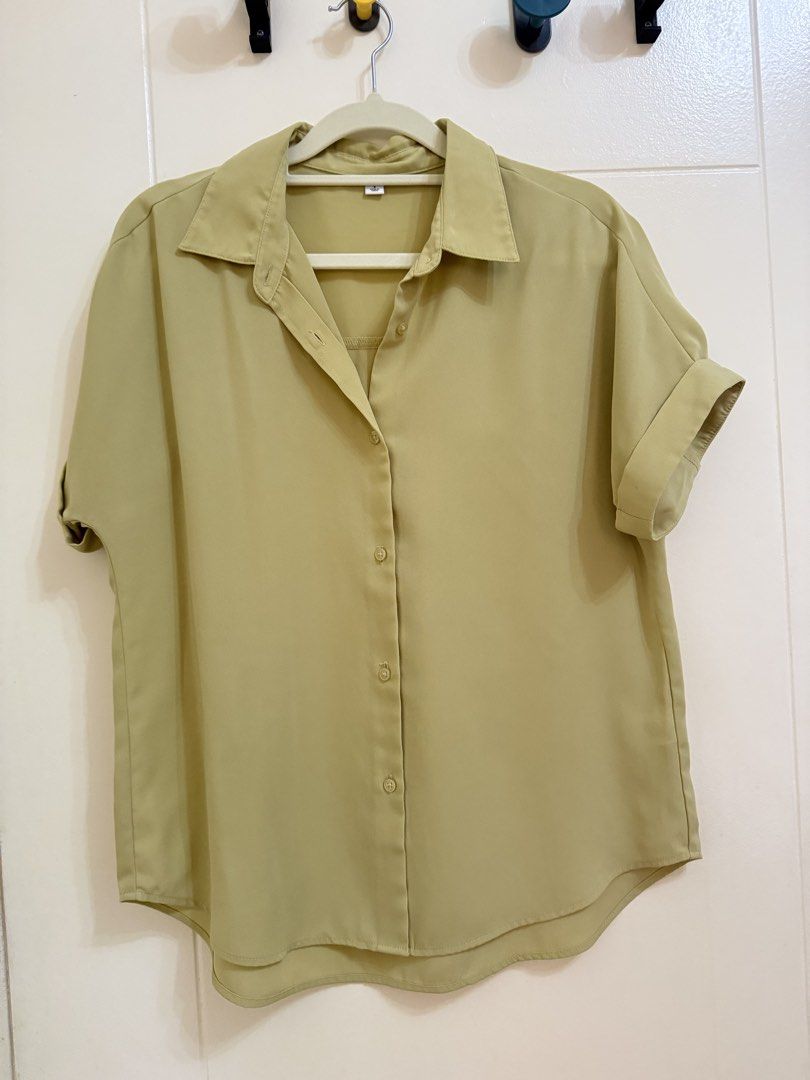 GU Short Sleeve Button-Down Shirt (Category: Shirts) located in Quezon City. Submitted by leah_decluttering (Listing ID 1469948258, Image 1). Description: - Color: Sage green - Style: Short-sleeve button-down shirt with a classic collared neckline - Details: Rolled sleeve cuffs and a curved hemline that is slightly longer in the back - Fabric: Lightweight material - Versatility: Easy to style with both trousers and denim.