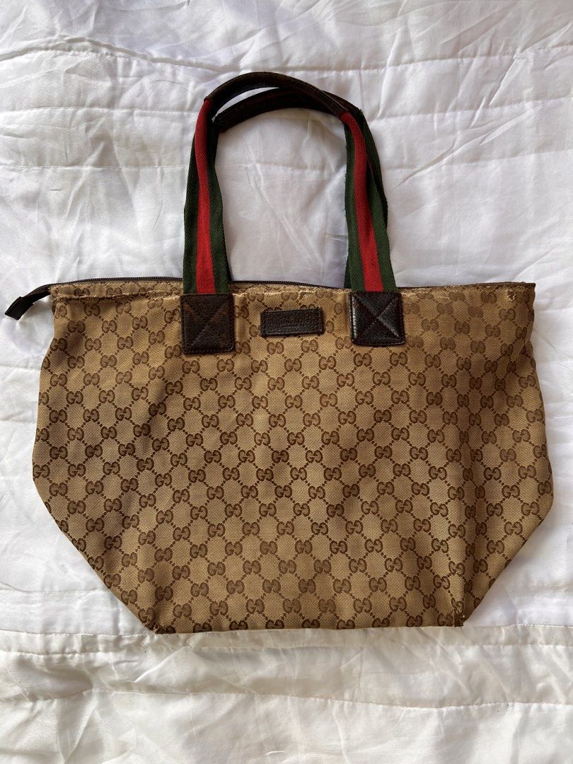 Gucci GG Monogram Web Stripe Tote Bag (Category: Luxury Bags & Wallets) located in Manila. Submitted by mightylion-ce6ea7 (Listing ID 1470032246, Image 1). Description: - Gucci tote bag with classic GG monogram canvas - Features premium brown leather trim and base - Signature red and green web stripe fabric handles - Secure zip closure across the top - Interior leather branding tag included - Condition: Shows visible wear on the handles, edges, a
