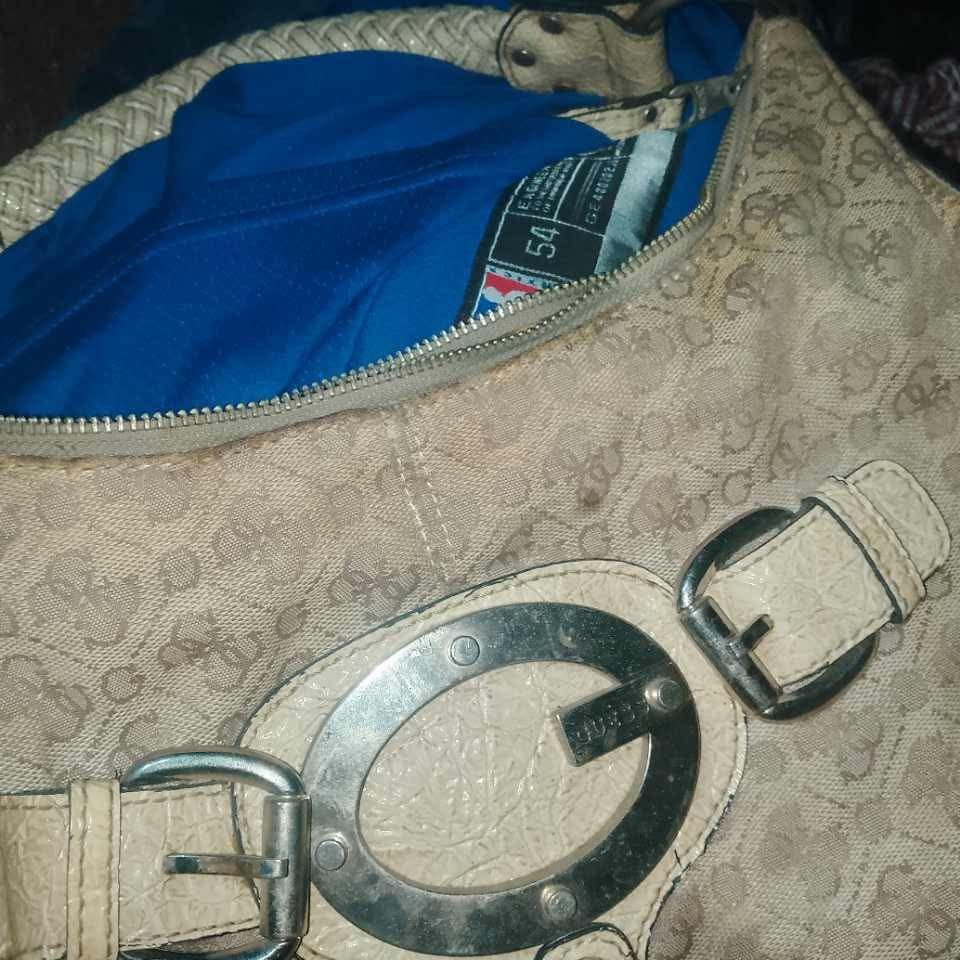 Guess Monogram Shoulder Bag Cream Beige Studded (Category: Shoulder Bags) located in Cainta. Submitted by riszizlux (Listing ID 1469845313, Image 3). Description: - Brand: Guess - Color/Pattern: Cream and beige monogram print - Hardware: Silver-tone with distinct front ring clasp - Handle: Braided top handle - Pockets: Dual exterior side pockets with zipper closures and stud detailing - Design: Slouchy hobo shape with a spacious interior - Condit