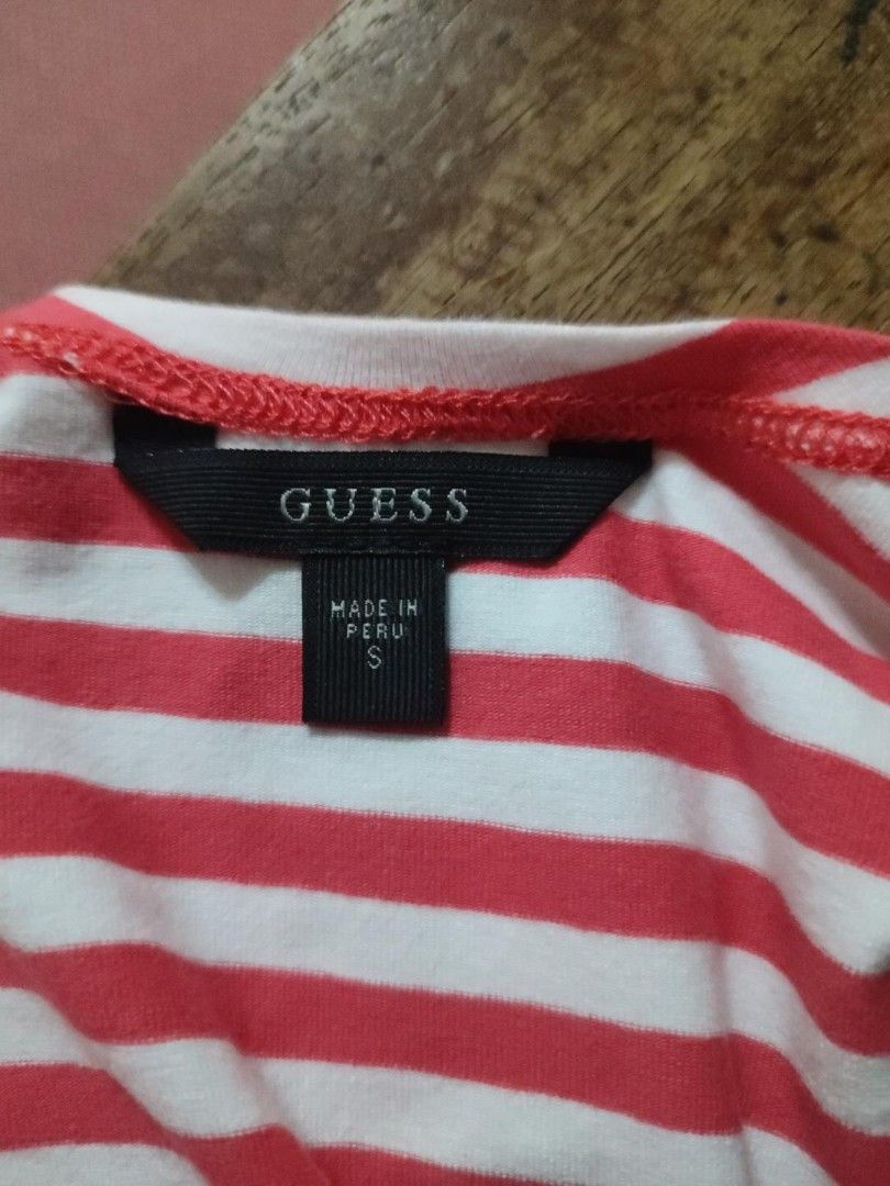 Guess Red and White Striped Top Size S (Category: Blouses) located in Cainta. Submitted by boldhorse_d62227 (Listing ID 1469956047, Image 2). Description: - Brand: Guess authentic - Color/Pattern: Red and white striped - Size: S (tag and care instructions attached) - Material: 95% cotton, 5% spandex (soft, stretchy, and comfortable) - Origin: Made in Peru - Design: Short sleeves, scoop neckline, and sparkly silver sequin lettering across the fron
