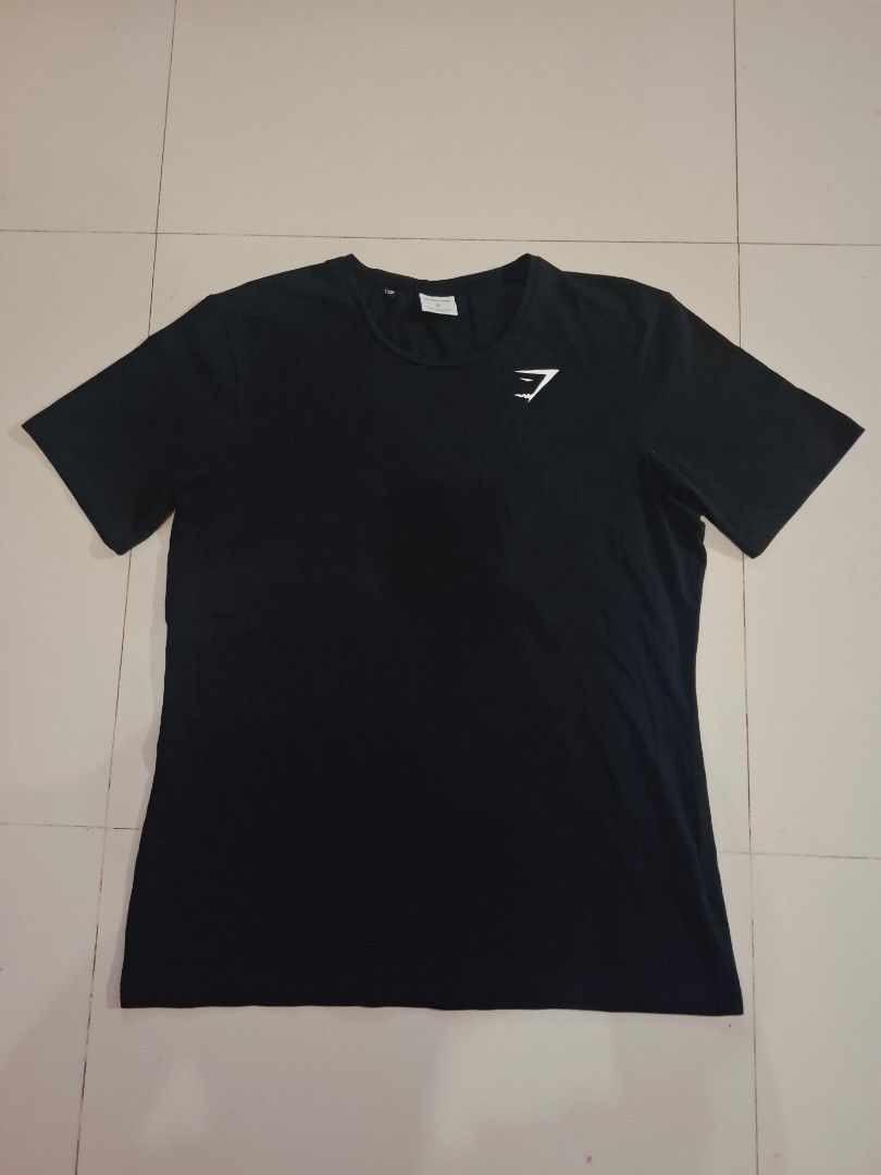 Gymshark black shirt (Category: Activewear) located in Narvacan. Submitted by jigger85_2ndaccount (Listing ID 1470080391, Image 1). Description: gymshark tshirt like new 9.8/10 condition no issue excellent condition size: xl on tag dimes: 21 x 28 can fit to medium to large loc. ilocos sur.