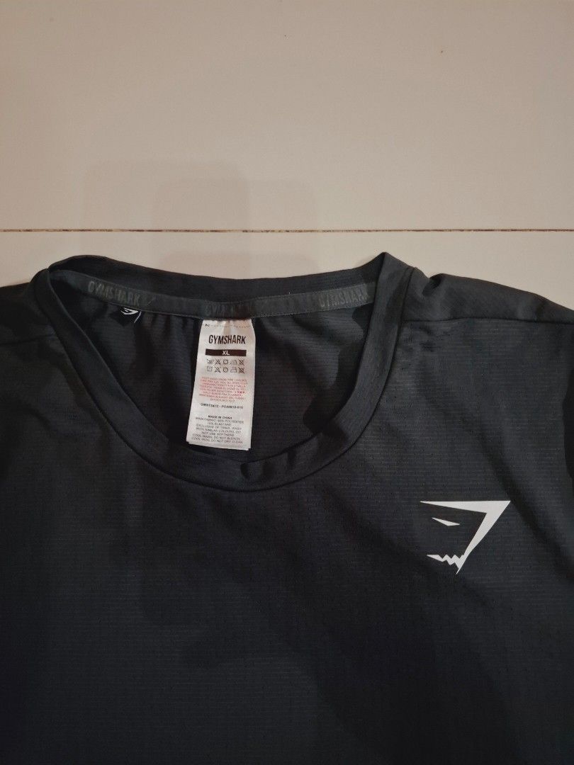 Gymshark drifit shirt (Category: Activewear) located in Narvacan. Submitted by jigger85_2ndaccount (Listing ID 1470083388, Image 2). Description: gymshark tshirt like new 9.7/10 condition no issue excellent condition dark gray color size: xl on tag dimes: 21 x 29 can fit to medium to large loc. ilocos sur.