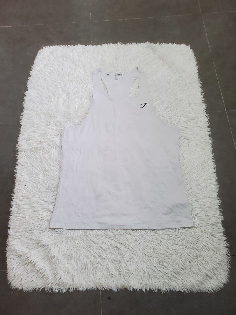 Gymshark White Training Tank Top Size L (Category: Activewear) located in Manila. Submitted by royalrabbit.7b2a11 (Listing ID 1470031013, Image 2). Description: - Brand: Gymshark - Color: White - Size: Large (L) - Material: Lightweight polyester and elastane blend - Design: Classic sleeveless gym cut with signature logo on the chest - Ideal for: Workouts, running, and lifting - Condition: Clean and well-maintained.