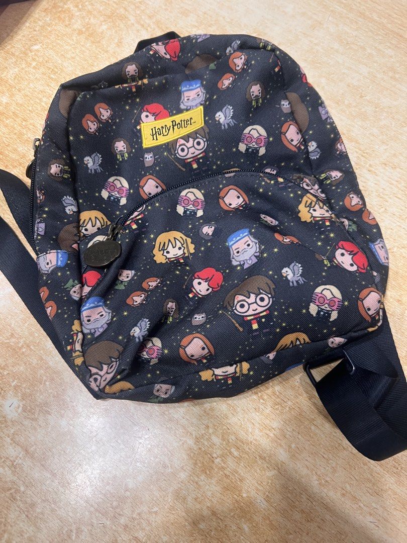 Harry Potter Jujube Mini Backpack Chibi Characters (Category: Backpacks) located in Davao. Submitted by sammmdizon7 (Listing ID 1470066586, Image 2). Description: - Authentic JuJuBe x Harry Potter collaboration mini backpack - Adorable chibi character print featuring Harry, Dumbledore, Luna, and more - Vibrant yellow Harry Potter brand patch on the front pocket - Custom metal zipper pulls with official brand logos - Convenient front zipper pocket