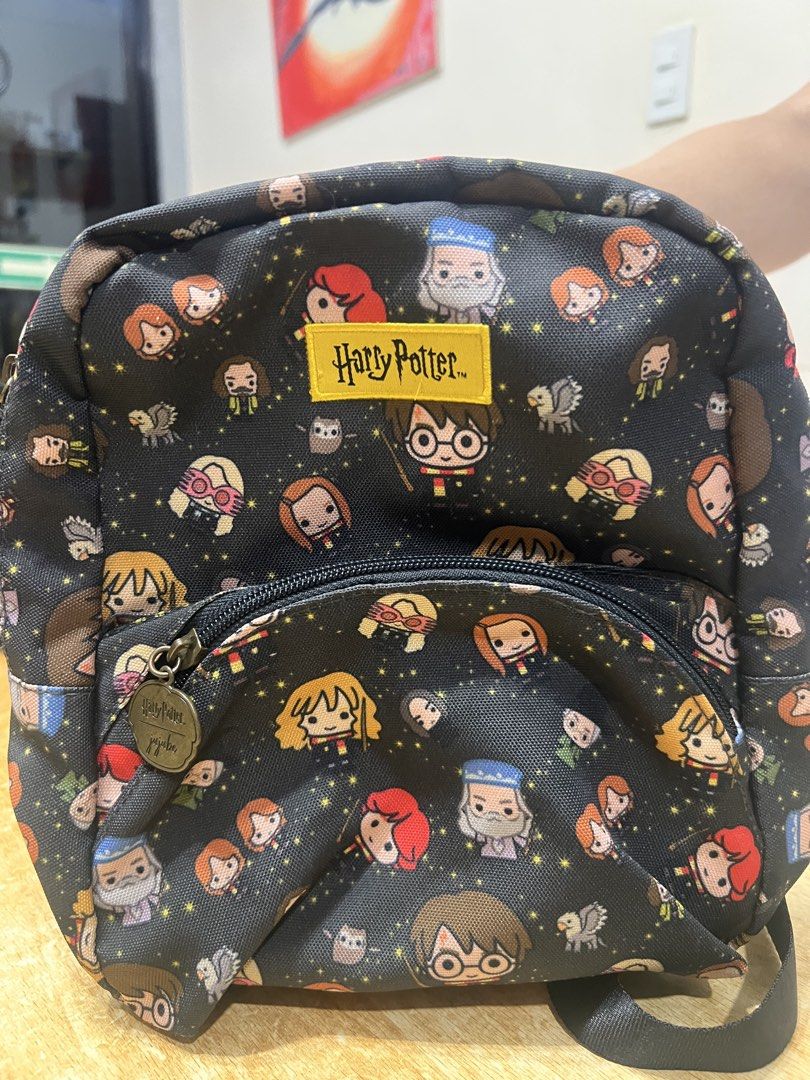 Harry Potter Jujube Mini Backpack Chibi Characters (Category: Backpacks) located in Davao. Submitted by sammmdizon7 (Listing ID 1470066586, Image 1). Description: - Authentic JuJuBe x Harry Potter collaboration mini backpack - Adorable chibi character print featuring Harry, Dumbledore, Luna, and more - Vibrant yellow Harry Potter brand patch on the front pocket - Custom metal zipper pulls with official brand logos - Convenient front zipper pocket