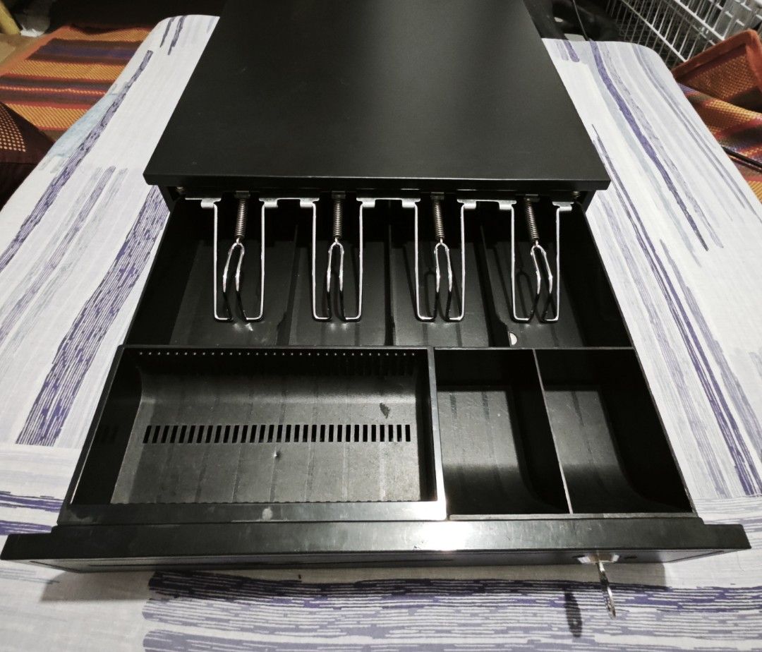 Heavy Duty Cash Register Drawer with Key (Category: Office & Business Technology) located in Valenzuela. Submitted by jacemarie (Listing ID 1470016258, Image 2). Description: - Color: Black - Heavy-duty build with included security key - 4 bill compartments with durable metal spring clips - Adjustable coin tray insert for custom organization - Convenient front media slot for receipts and slips - Clean and well-maintained interior layout.